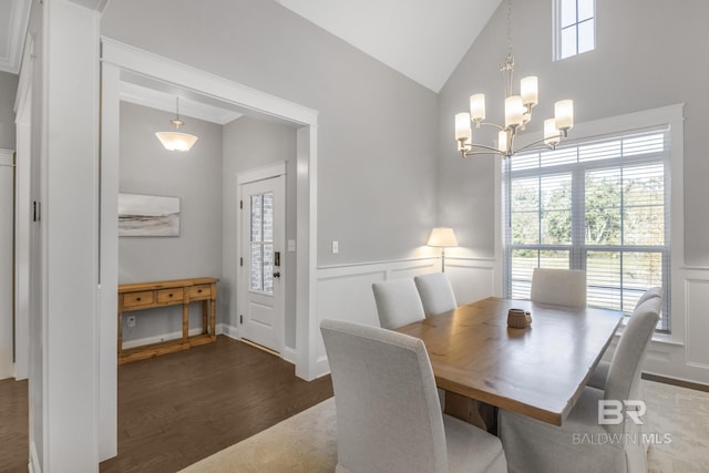 dining room with dark hardwood / wood-style flooring, lofted ceiling, and an inviting chandelier