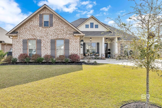 view of front facade featuring a front lawn, brick siding, and a shingled roof