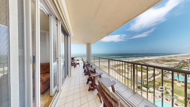 balcony featuring a water view and a view of the beach