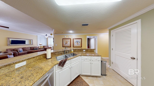 kitchen with sink, stone countertops, a textured ceiling, kitchen peninsula, and white cabinets