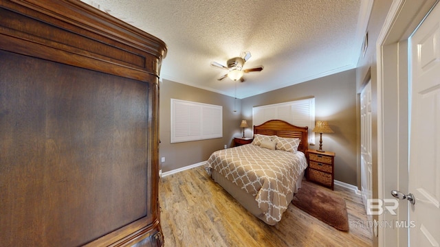 bedroom with ornamental molding, a textured ceiling, ceiling fan, and light hardwood / wood-style floors