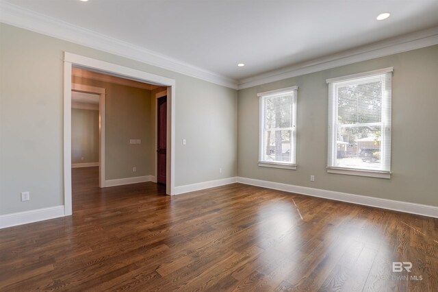 spare room with dark wood-type flooring, recessed lighting, ornamental molding, and baseboards