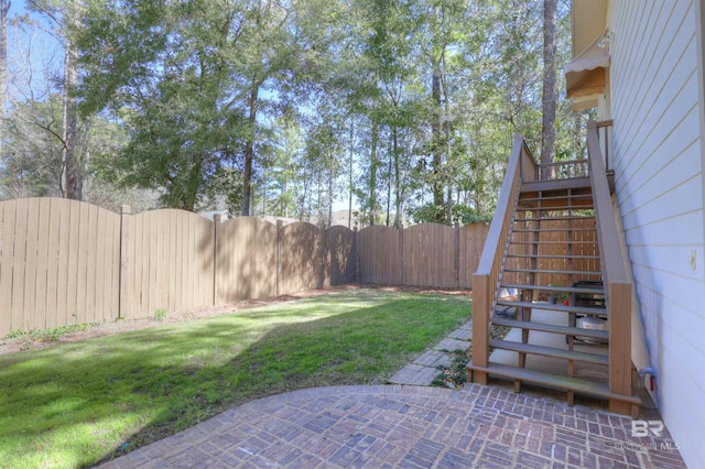 view of yard featuring a fenced backyard and stairway