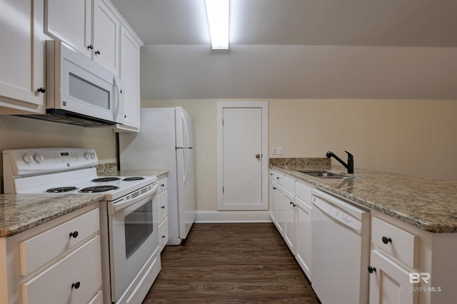 kitchen with a peninsula, white appliances, a sink, white cabinets, and dark wood finished floors