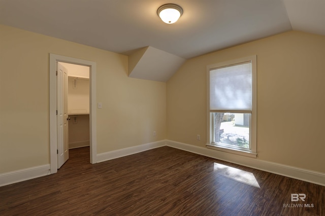 bonus room with dark wood-style flooring, vaulted ceiling, and baseboards