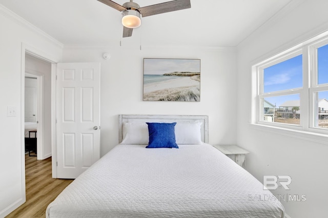 bedroom with crown molding, ceiling fan, and light wood-type flooring