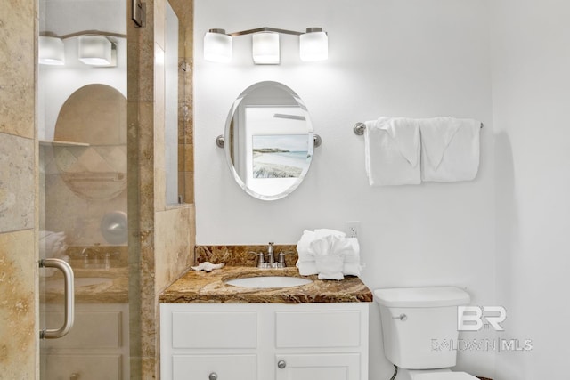 bathroom with vanity, a shower with shower door, and toilet