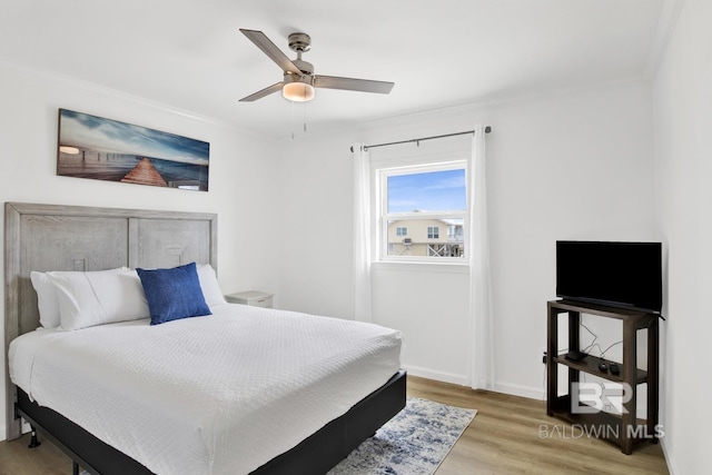 bedroom featuring hardwood / wood-style floors, ornamental molding, and ceiling fan