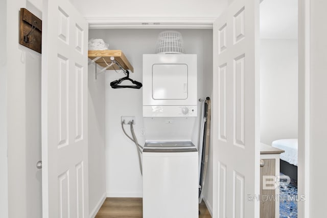 laundry room featuring wood-type flooring and stacked washer and clothes dryer