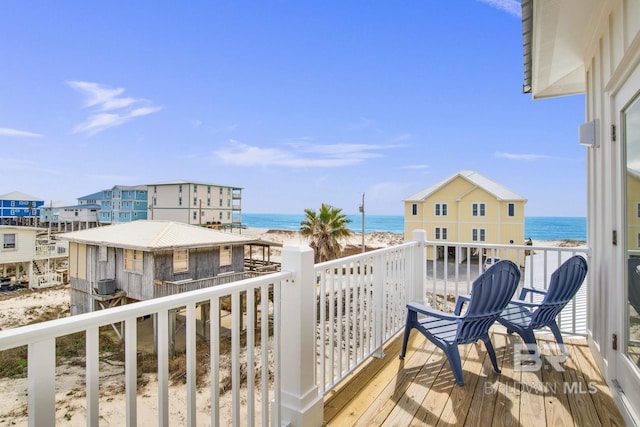 balcony featuring a water view, central air condition unit, and a view of the beach