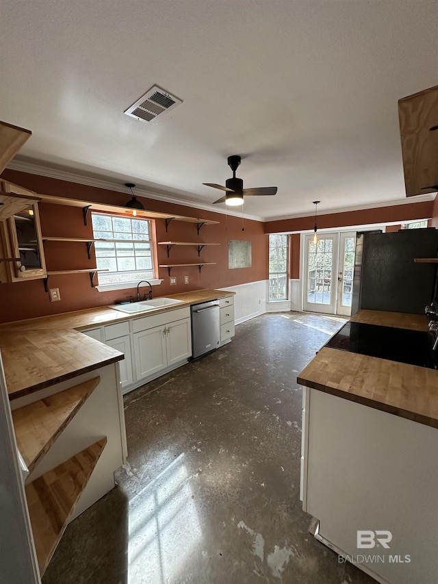 kitchen featuring pendant lighting, sink, butcher block counters, white cabinets, and stainless steel dishwasher