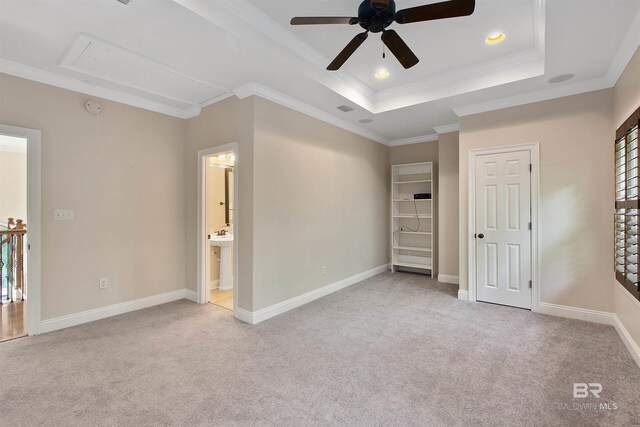 carpeted spare room featuring ornamental molding, ceiling fan, and a tray ceiling