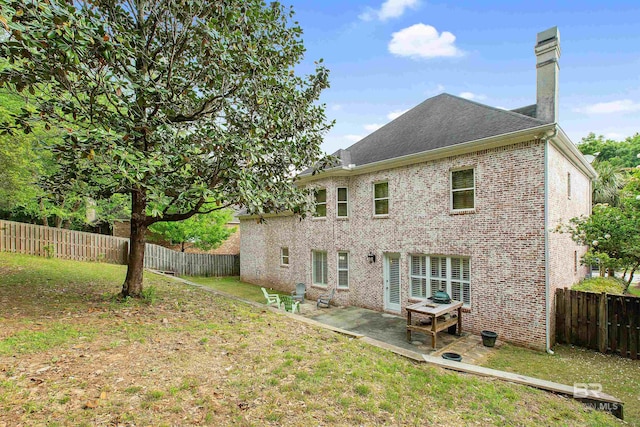 rear view of property featuring a lawn and a patio