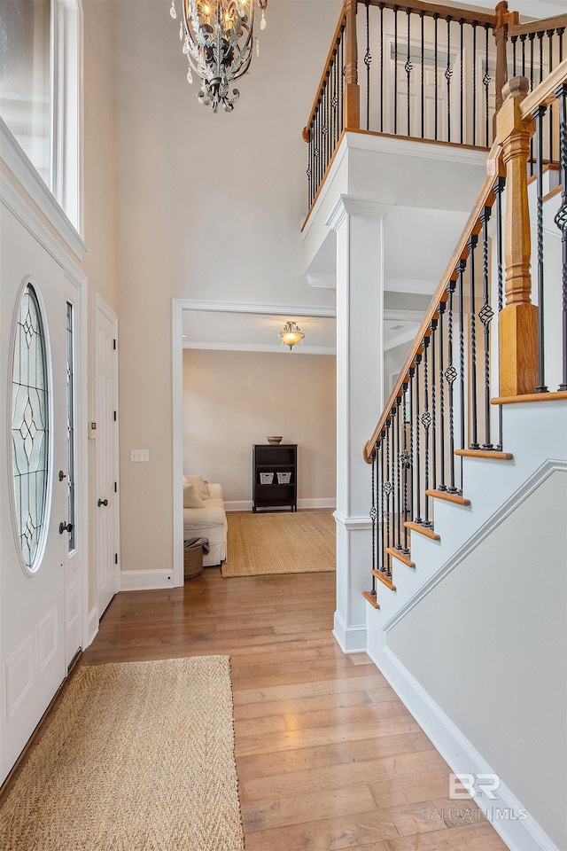 foyer featuring a notable chandelier, a high ceiling, and light wood-type flooring