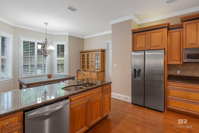 kitchen with a chandelier, tasteful backsplash, light hardwood / wood-style flooring, appliances with stainless steel finishes, and sink