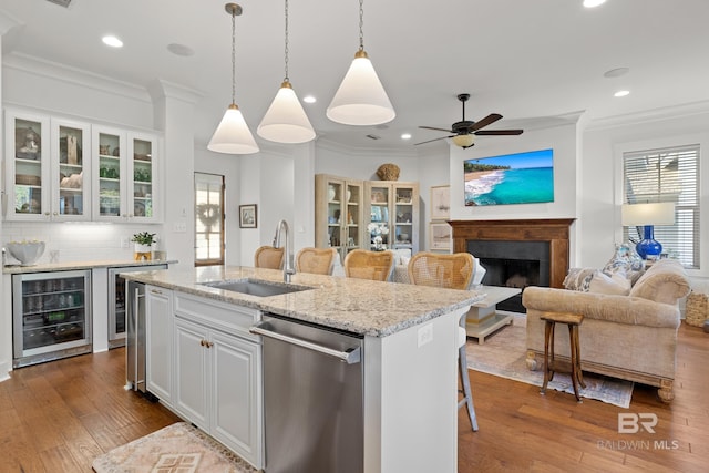 kitchen featuring dishwasher, a sink, crown molding, and wine cooler