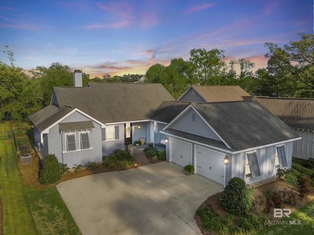 ranch-style home with driveway, a chimney, board and batten siding, and roof with shingles