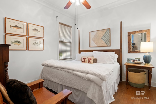 bedroom featuring baseboards, ornamental molding, wood finished floors, and ceiling fan