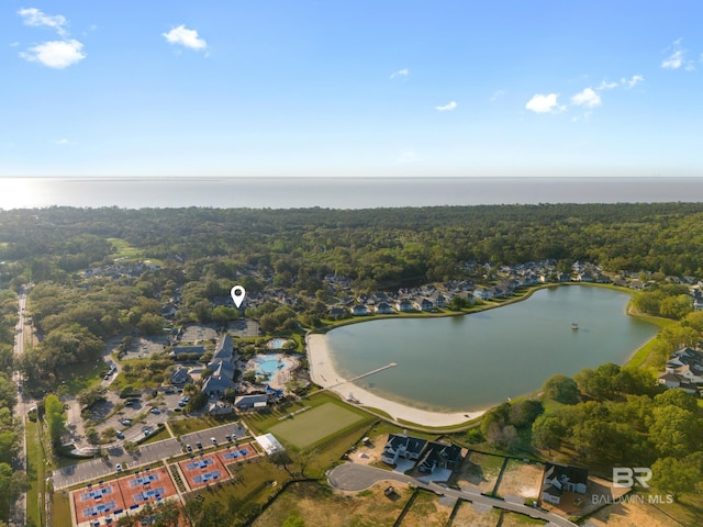 birds eye view of property featuring a water view and a wooded view