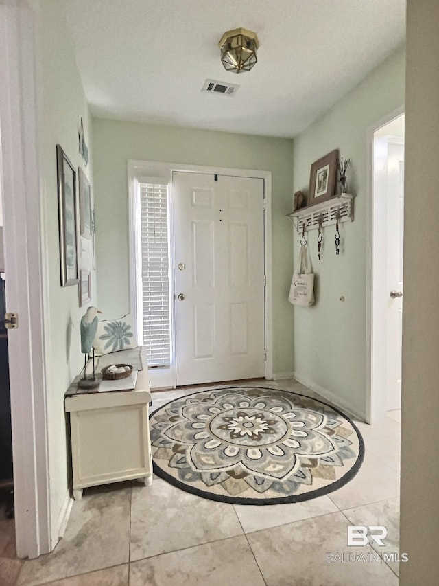 tiled foyer with visible vents and baseboards