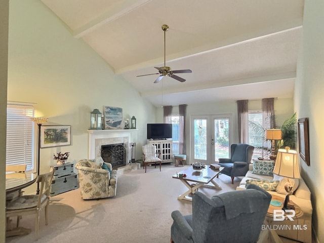 carpeted living room with a ceiling fan, a tile fireplace, french doors, high vaulted ceiling, and beam ceiling