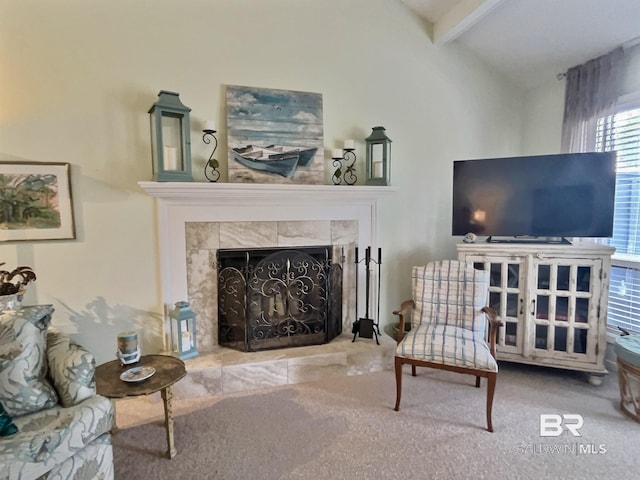 carpeted living area with lofted ceiling with beams and a tiled fireplace