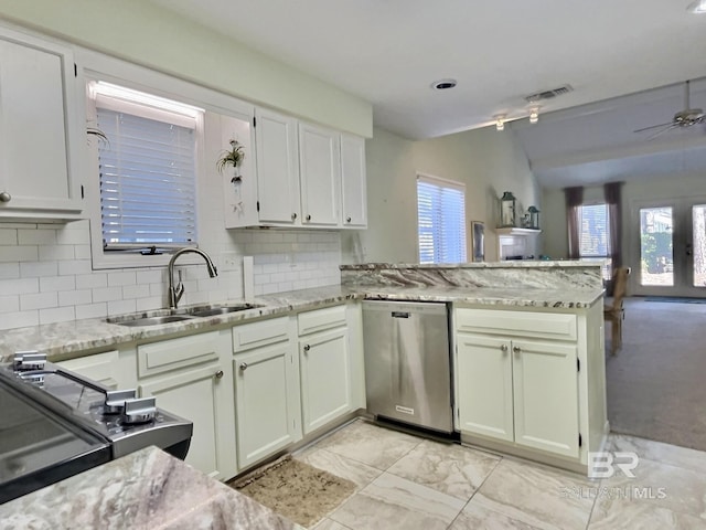 kitchen with a wealth of natural light, visible vents, stainless steel dishwasher, a sink, and a peninsula