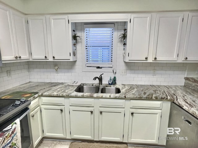 kitchen with stainless steel appliances, tasteful backsplash, a sink, and light stone counters