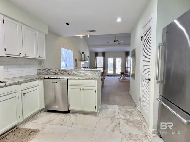 kitchen with french doors, stainless steel appliances, tasteful backsplash, visible vents, and a peninsula