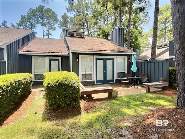 rear view of house with french doors and board and batten siding