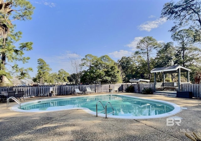 pool featuring fence and a patio