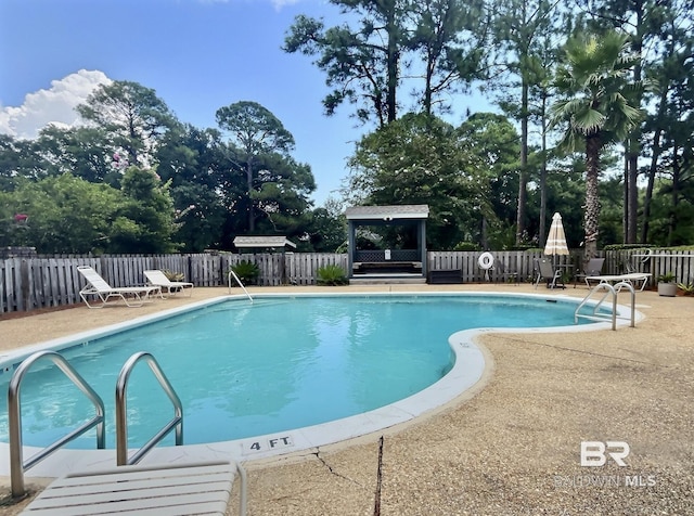 pool featuring a patio area, a fenced backyard, and a gazebo