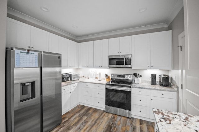 kitchen with ornamental molding, dark wood finished floors, light stone counters, white cabinets, and appliances with stainless steel finishes