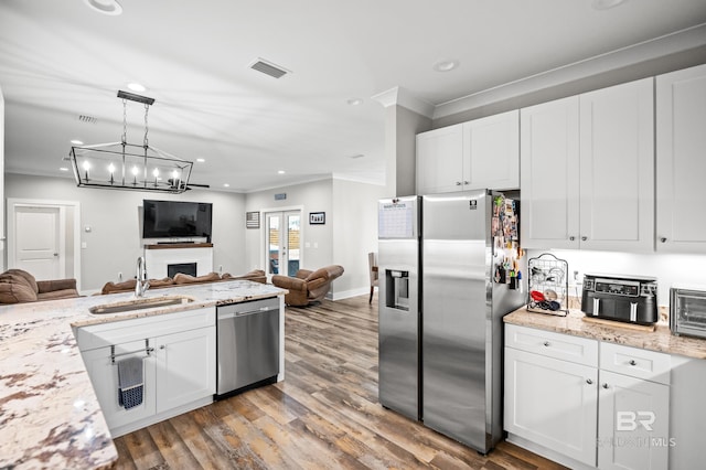 kitchen featuring open floor plan, a sink, stainless steel appliances, and visible vents