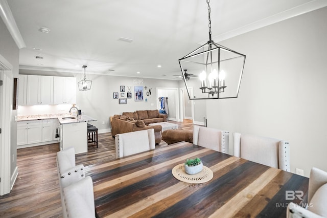 dining space featuring crown molding, baseboards, recessed lighting, dark wood-type flooring, and a notable chandelier