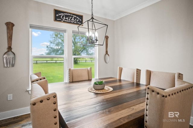 dining room with crown molding, baseboards, a chandelier, and wood finished floors