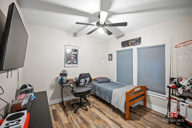 bedroom with baseboards, wood finished floors, and a ceiling fan