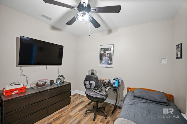 bedroom featuring baseboards, ceiling fan, visible vents, and light wood finished floors