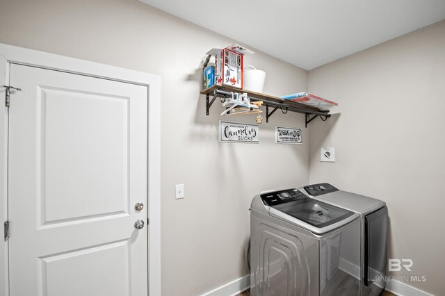 washroom with baseboards, washing machine and dryer, and laundry area