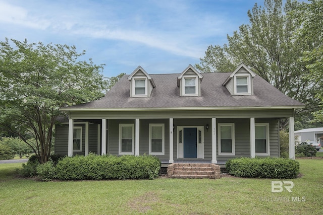 new england style home with covered porch and a front lawn