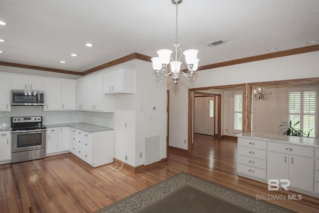 kitchen with white cabinetry, hanging light fixtures, a notable chandelier, and stainless steel appliances