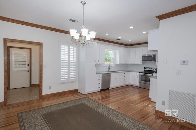 kitchen with dark hardwood / wood-style floors, sink, white cabinets, hanging light fixtures, and stainless steel appliances