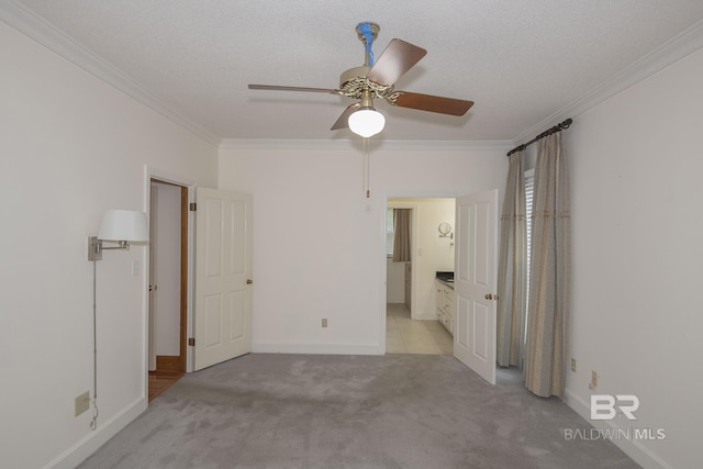 unfurnished room with ceiling fan, light colored carpet, ornamental molding, and a textured ceiling