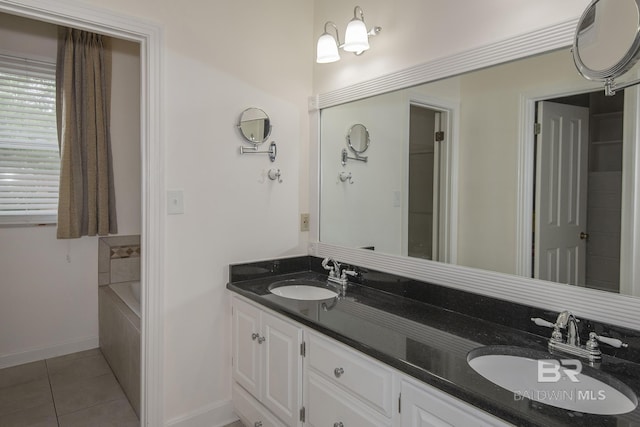 bathroom featuring tile patterned flooring, vanity, and tiled tub