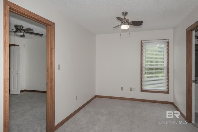 unfurnished bedroom with ceiling fan, light colored carpet, and a textured ceiling