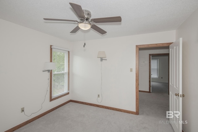 unfurnished room featuring light carpet, ceiling fan, and a textured ceiling