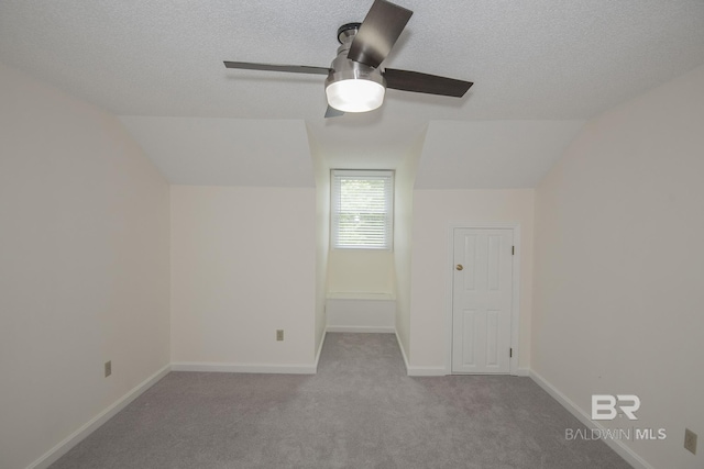 bonus room featuring light colored carpet, lofted ceiling, and a textured ceiling