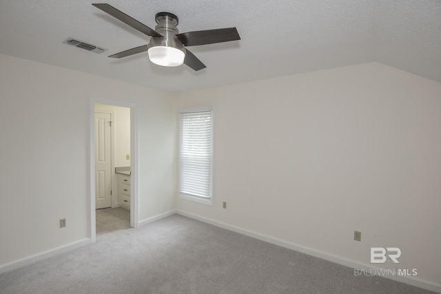 unfurnished bedroom featuring ceiling fan, light carpet, and a textured ceiling