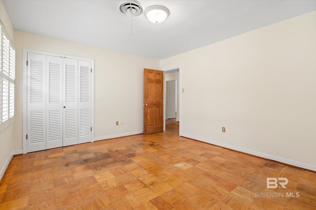 unfurnished bedroom featuring multiple windows and light parquet flooring