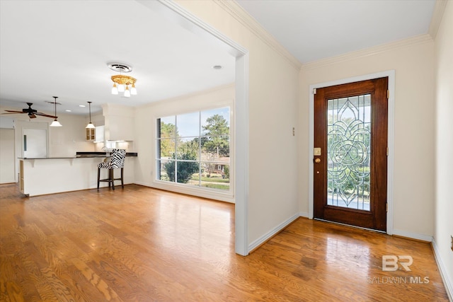 entryway with crown molding, light hardwood / wood-style flooring, and ceiling fan